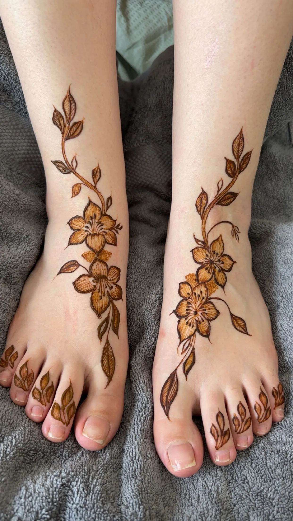 Floral henna on both feet with leaf details on the toes