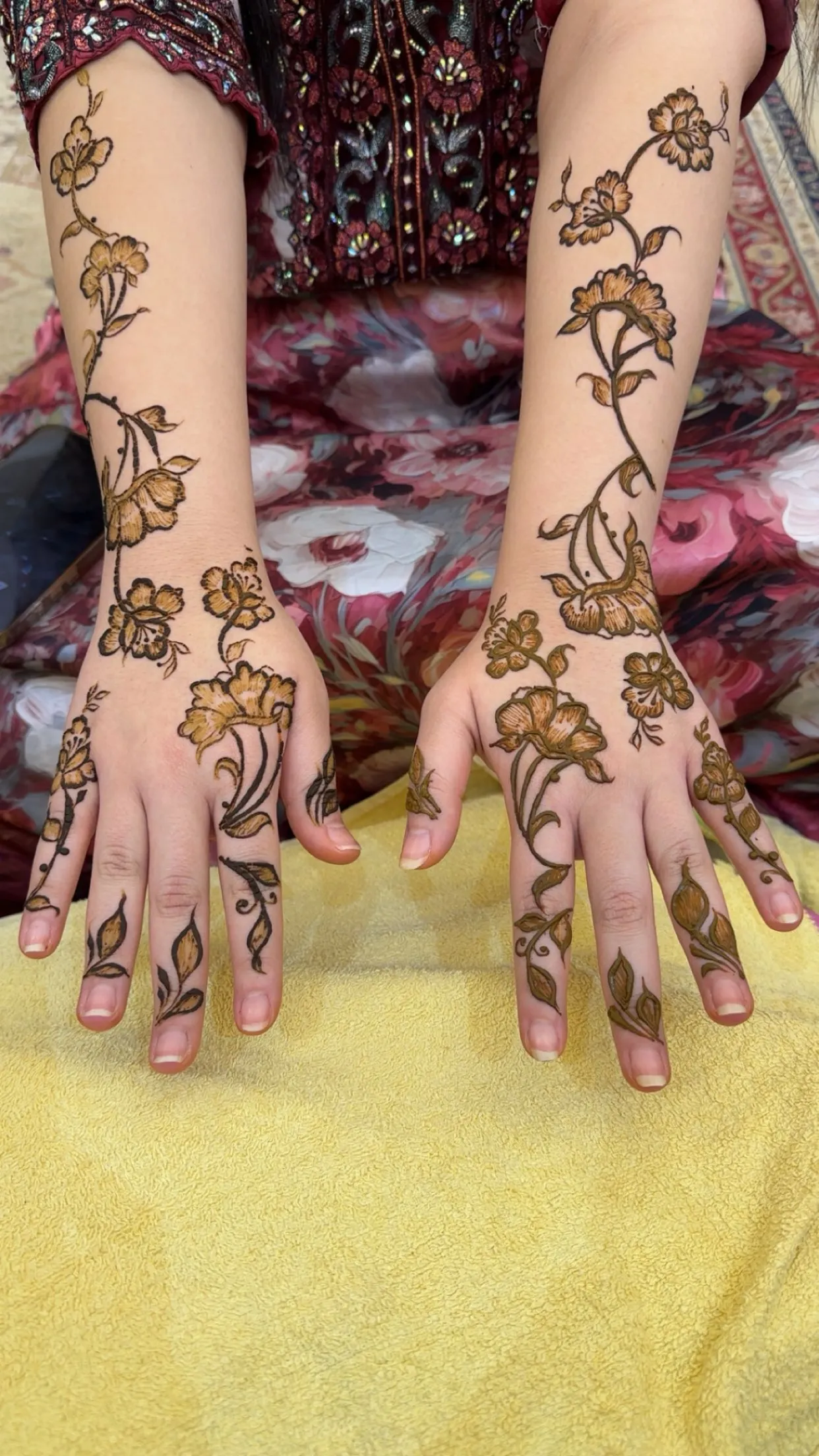 Matching floral henna vines on both hands and forearms