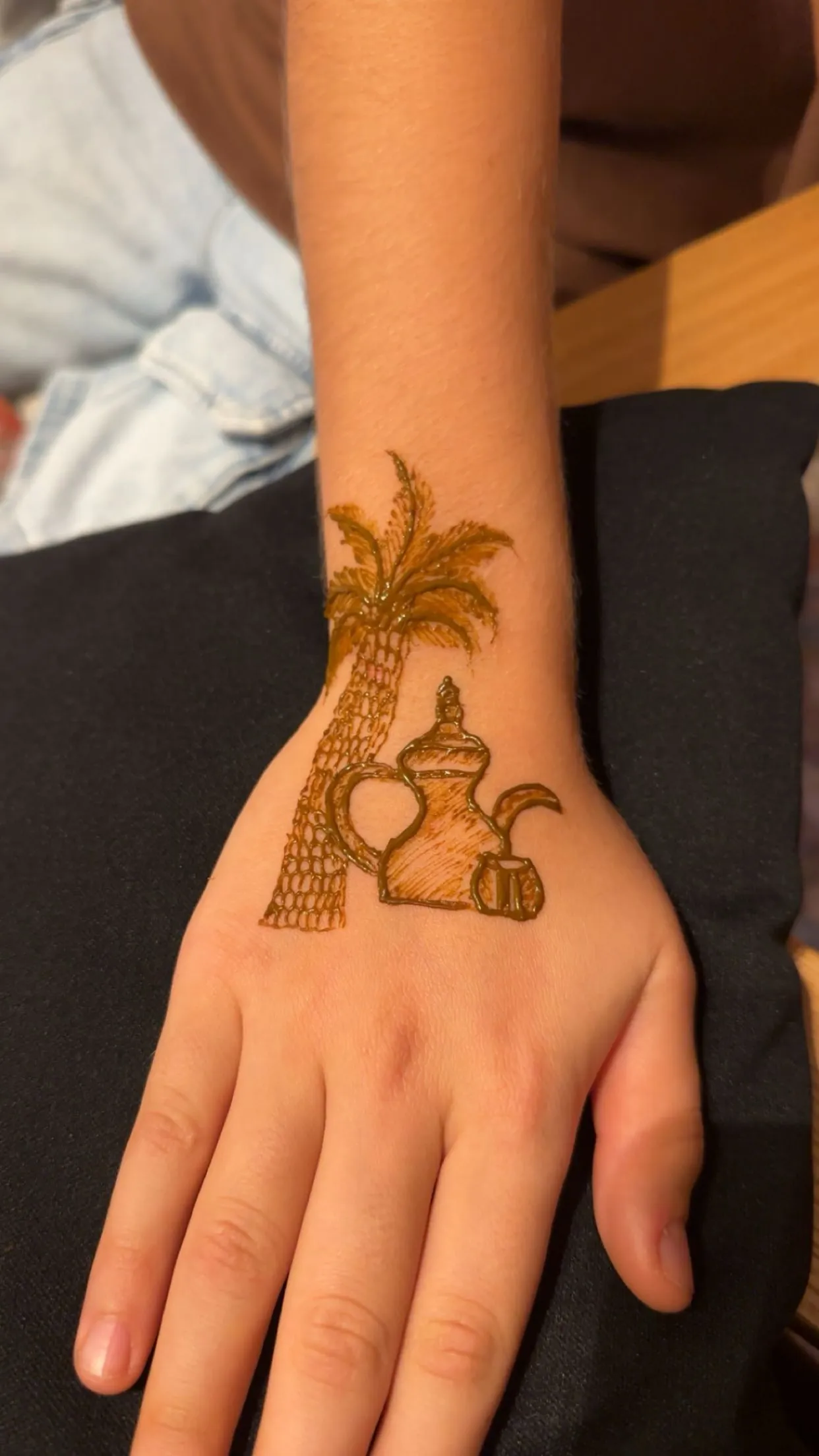 UAE-inspired henna of a palm tree and dallah coffee pot on a child's hand in Dubai